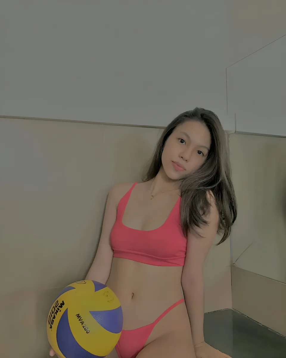 Abegail Bennett in pink sports top and bottom holding volleyball