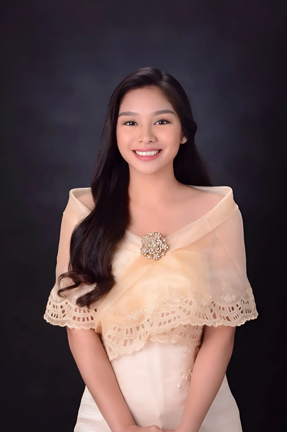 Alyana Lizada in beige lace top with decorative brooch, smiling at camera
