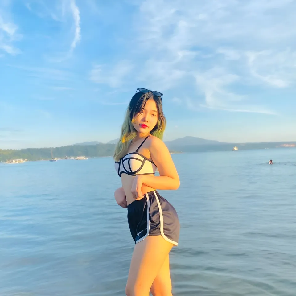 Alyanah Reed wearing black and white swimwear stands in calm coastal water