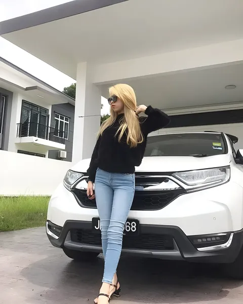 Anis Jade Bennett in black top and jeans stands beside white SUV