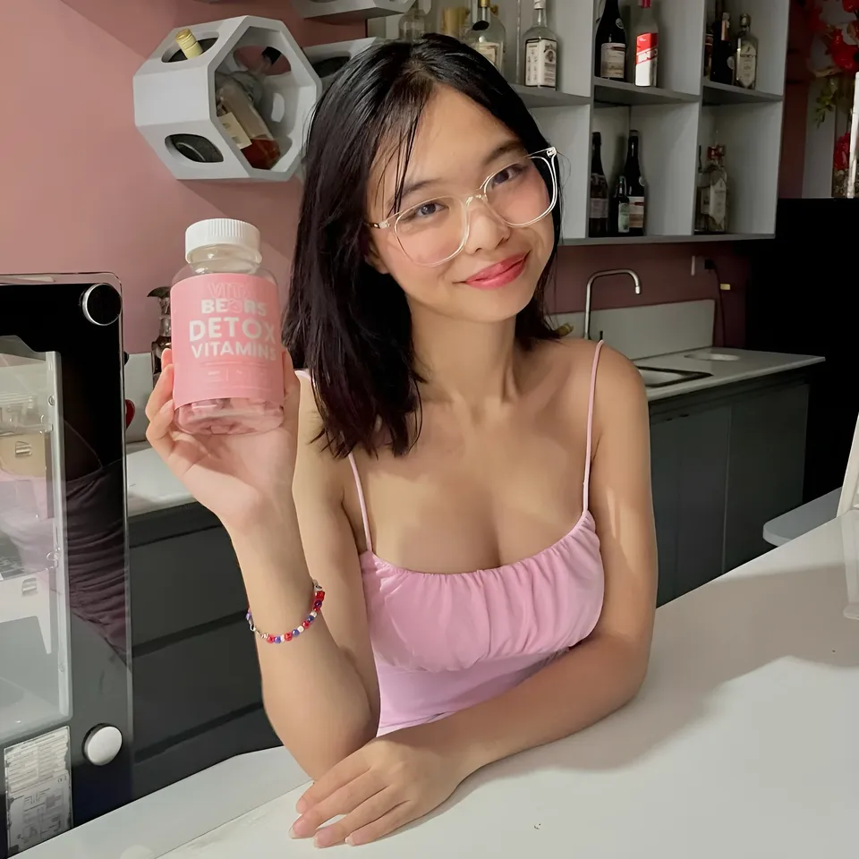 Beri Sinclair holding pink bottle in kitchen setting