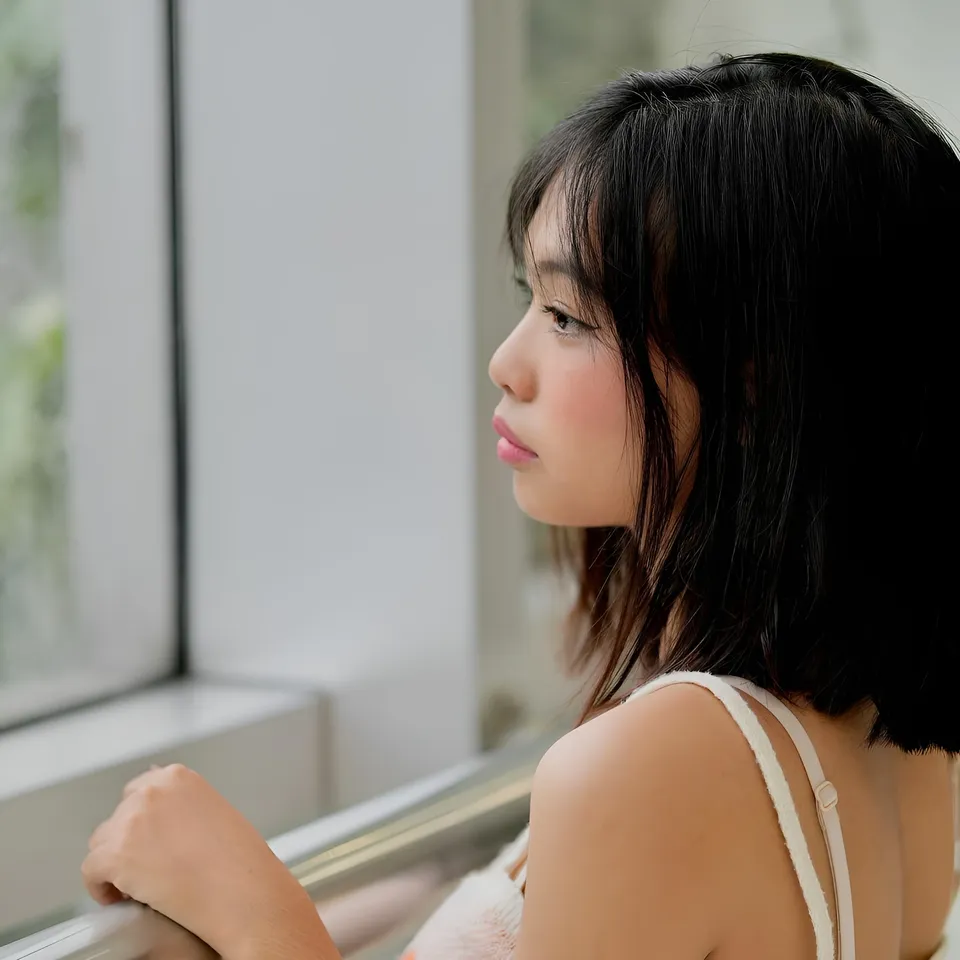 Beri Sinclair in white top looking out window from side profile