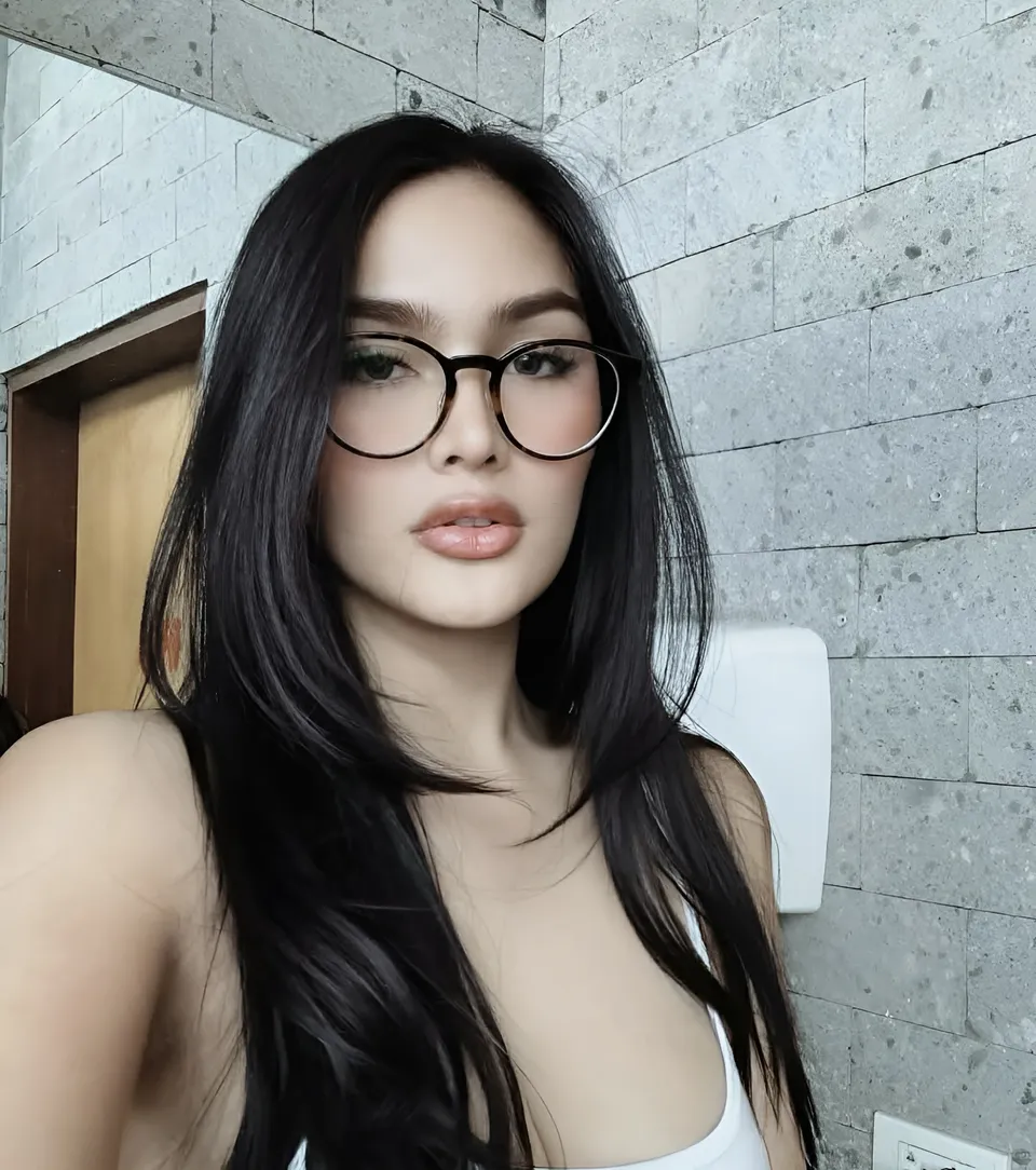 Brey Marti with glasses and long dark hair wearing white top