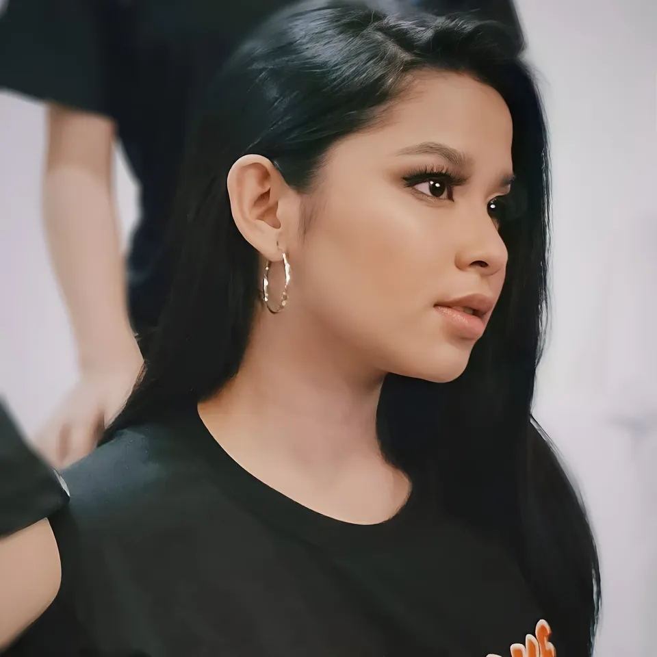 Callista Ray in black top with hoop earrings in close-up portrait