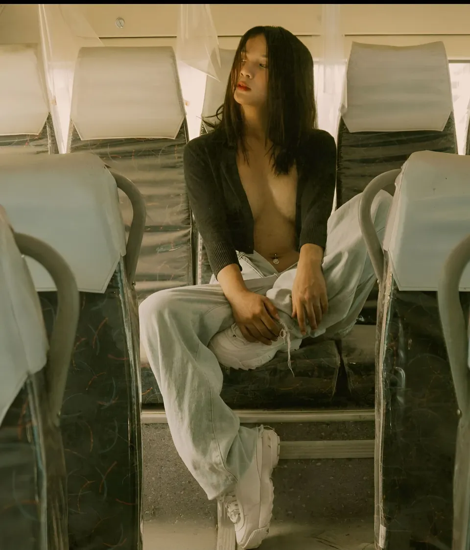 Cariza Tiglao seated in bus with open cardigan and light pants
