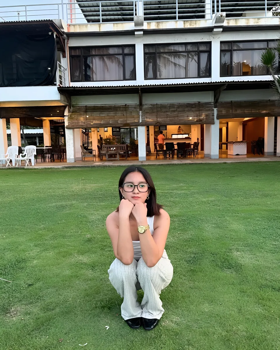 Cassidy Rowan crouching on grass in front of building