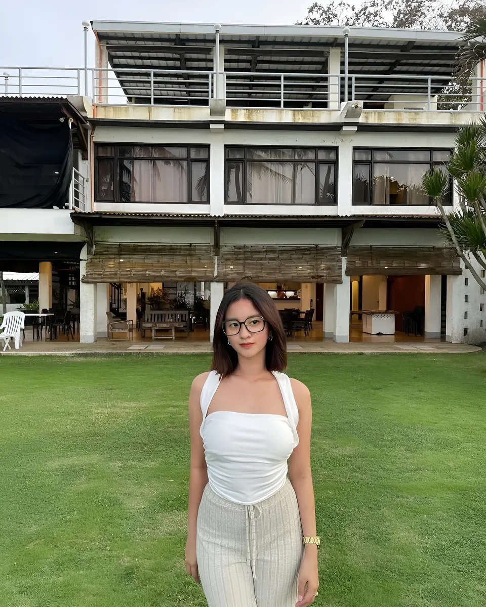 Cassidy Rowan in white top stands on grass in front of building