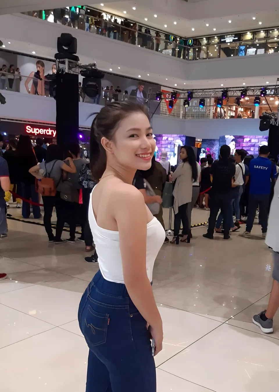 Charlene Migalang in white top and jeans stands in a shopping mall