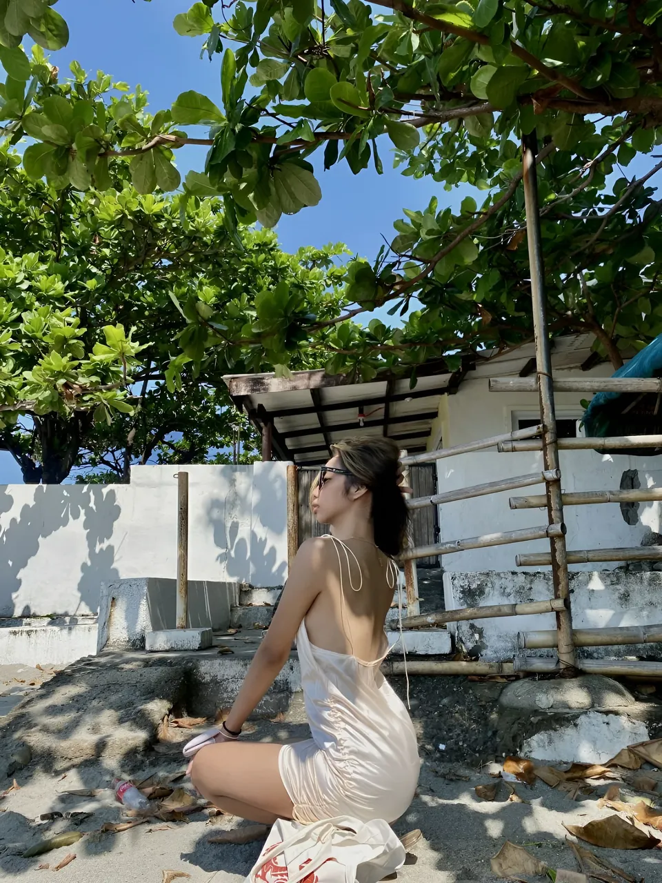 Czarina Blake in white dress sitting under tree outdoors