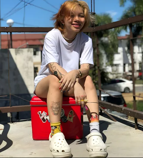 Danielle Dora sitting on red cooler outdoors