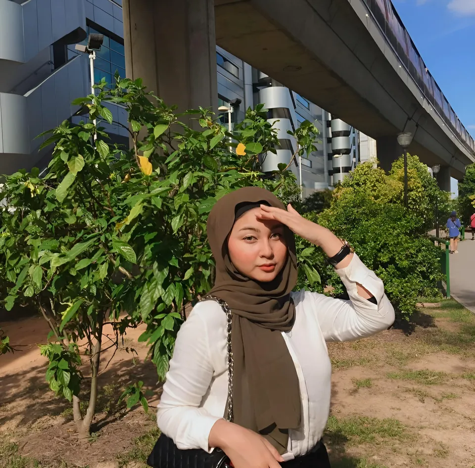 Danisha Vale wearing white top and brown hijab stands outdoors under bridge