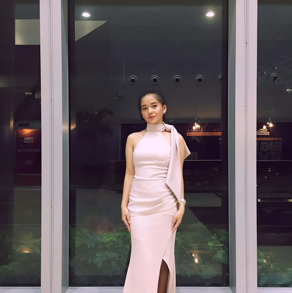 Diedre Anne in pink gown standing in front of glass doors