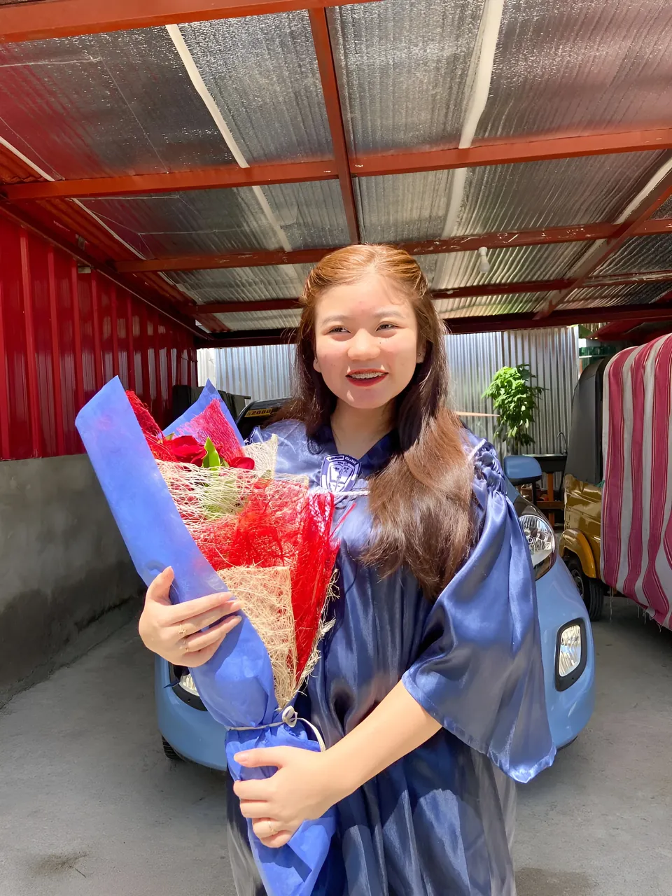 Ellidiethe Rielle in blue gown holding bouquet under shelter