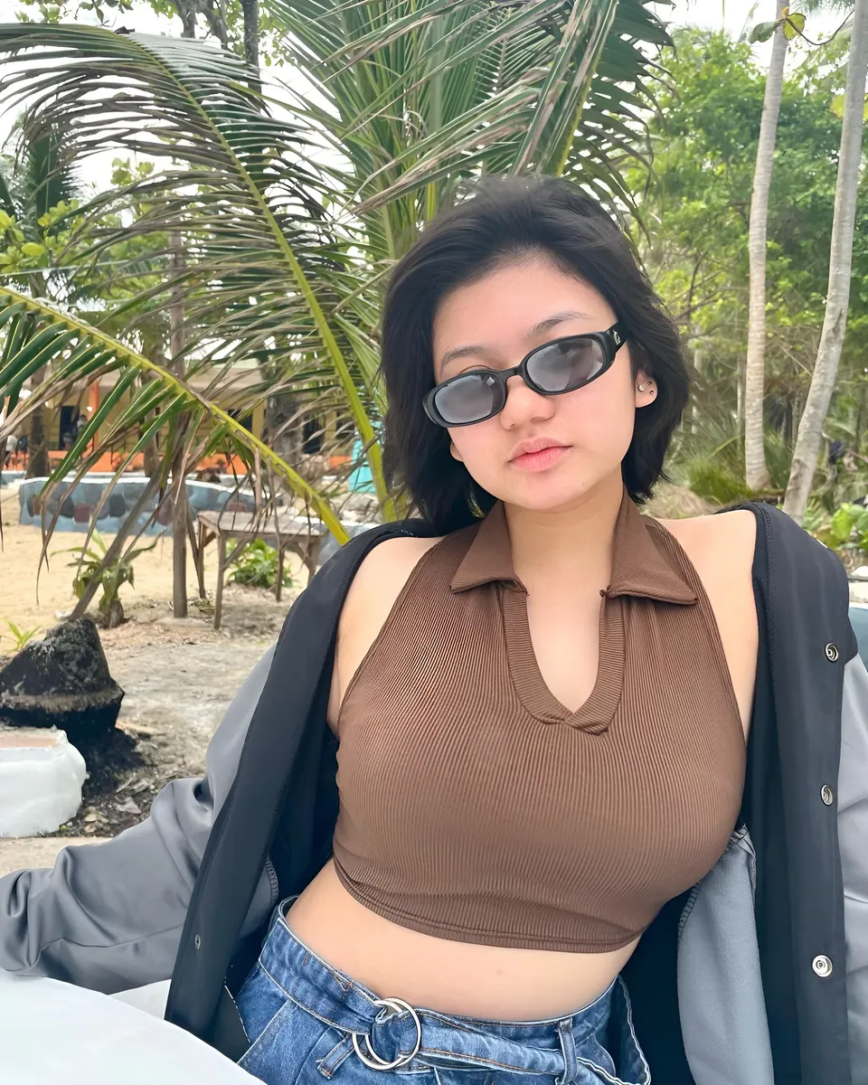 Ellidiethe Rielle wearing brown crop top and sunglasses outdoors near palm trees