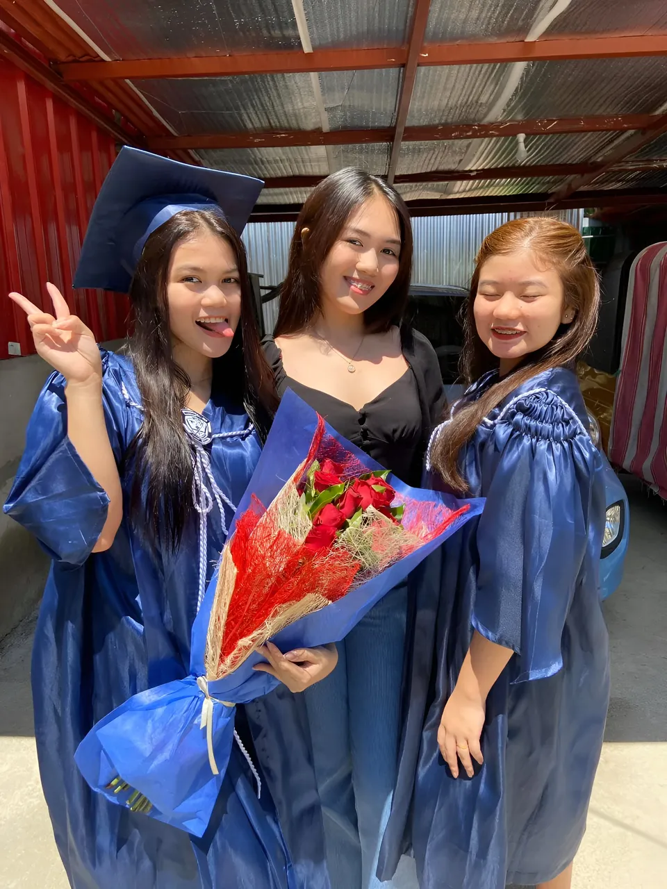 Ellidiethe Rielle — Three people pose together with blue gowns and a bouquet of flowers