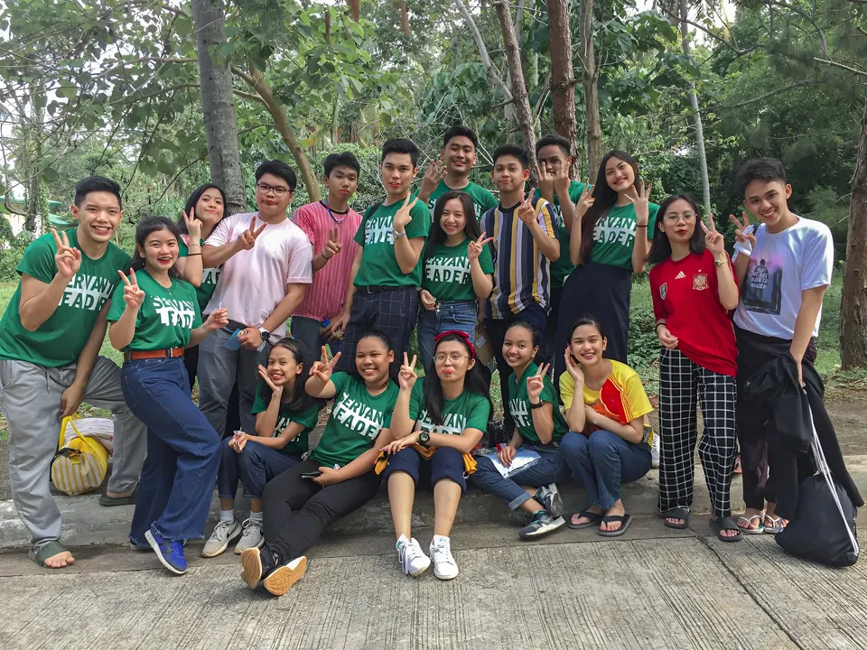 Ellidiethe Rielle — Group of people posing outdoors in green shirts and casual attire