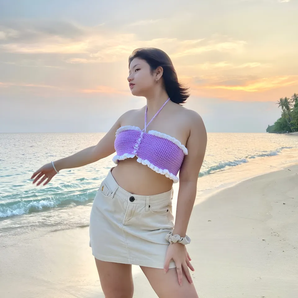 Ellidiethe Rielle in purple crochet top and beige skirt on beach at sunset