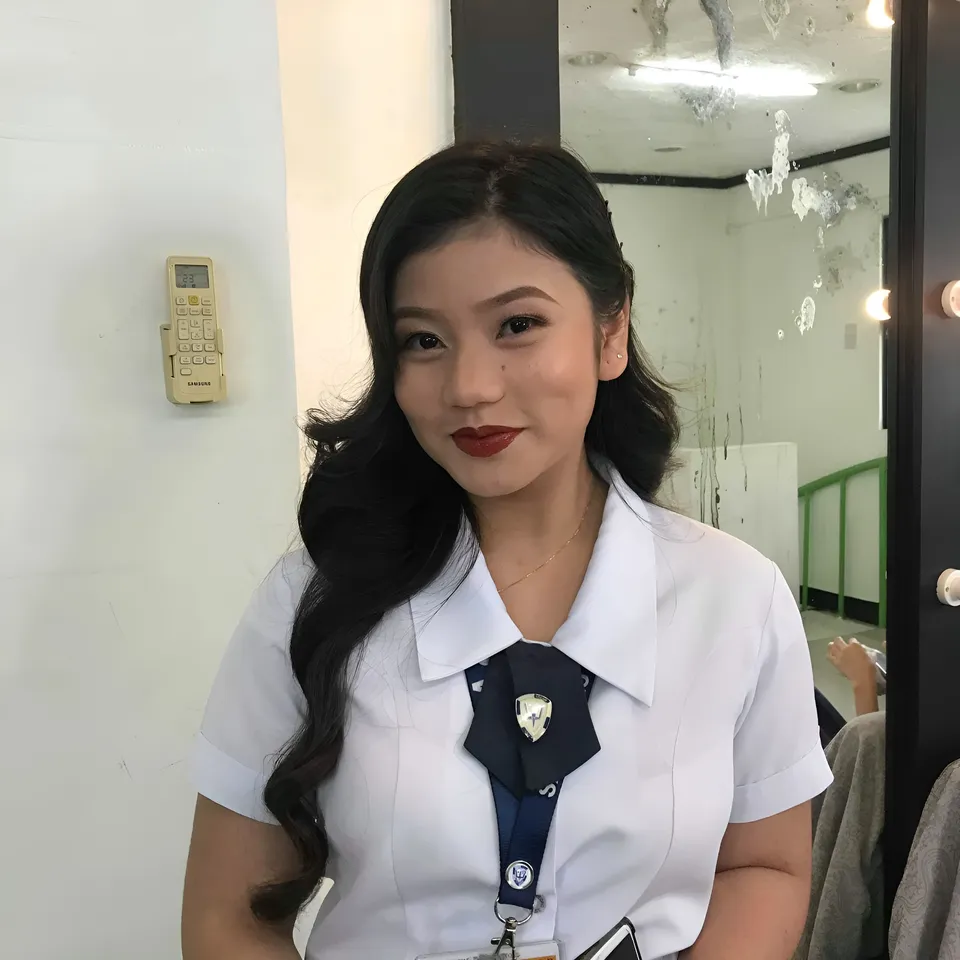 Ellidiethe Rielle in white shirt and dark tie standing indoors