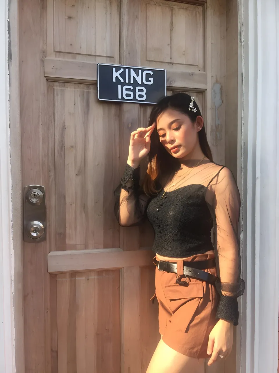 Faith Hope standing beside wooden door with sign