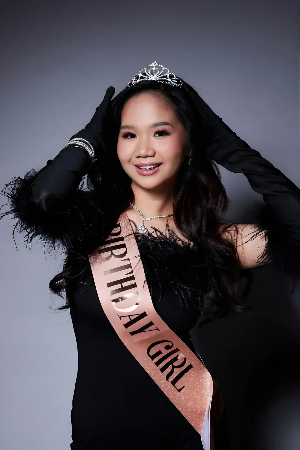 Faye Ramos in black feathered top with tiara and sash