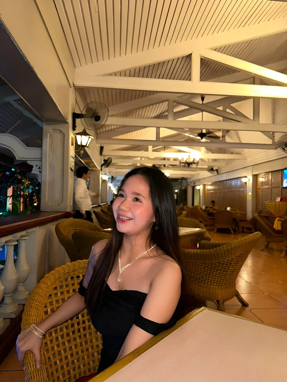 Faye Ramos in black top seated at table in restaurant