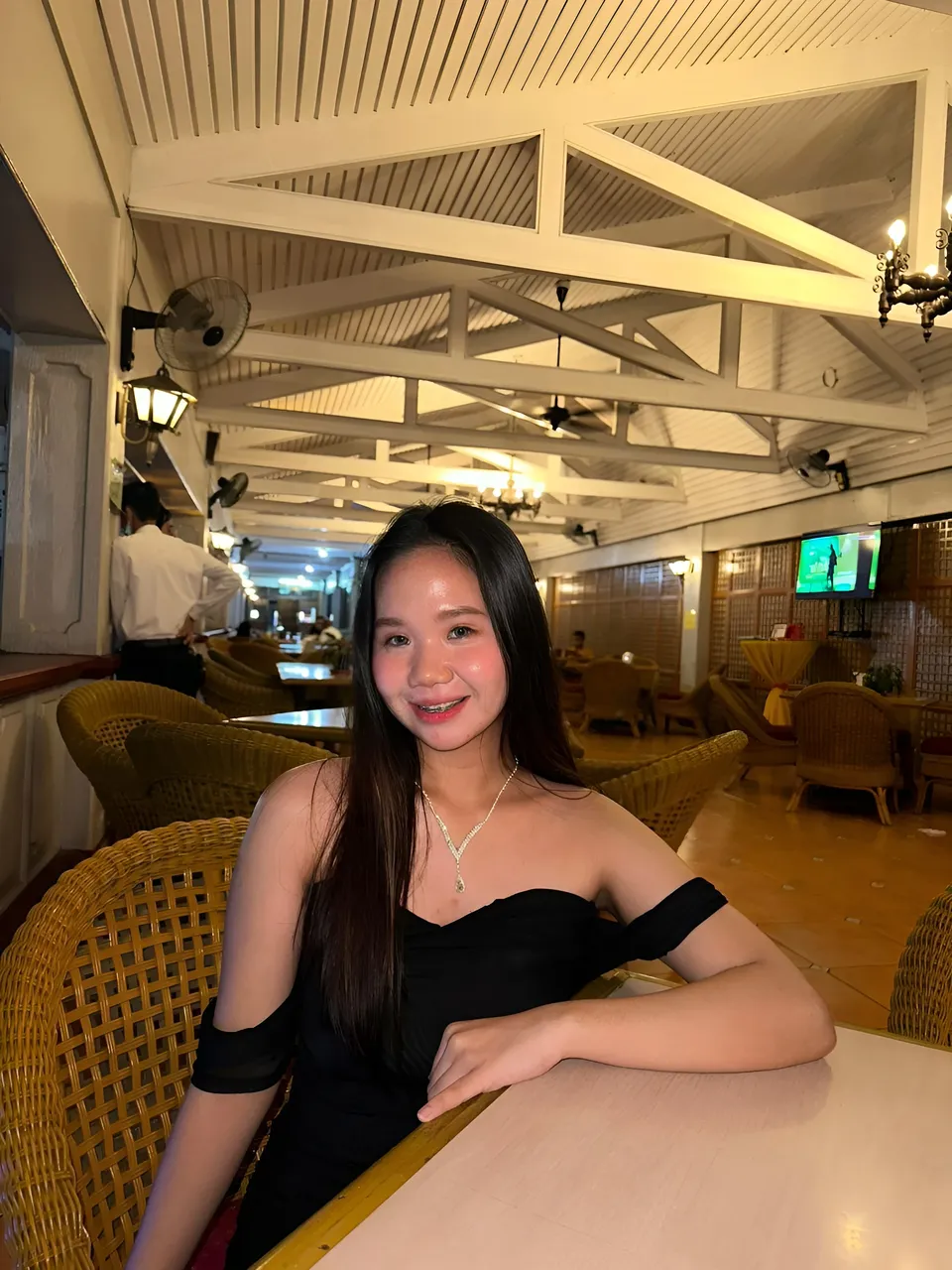 Faye Ramos in black off-shoulder top seated at table