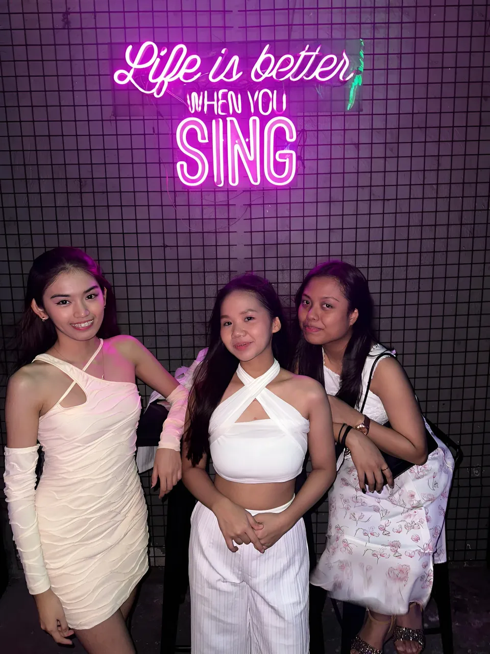 Faye Ramos — Three people posing in front of neon sign