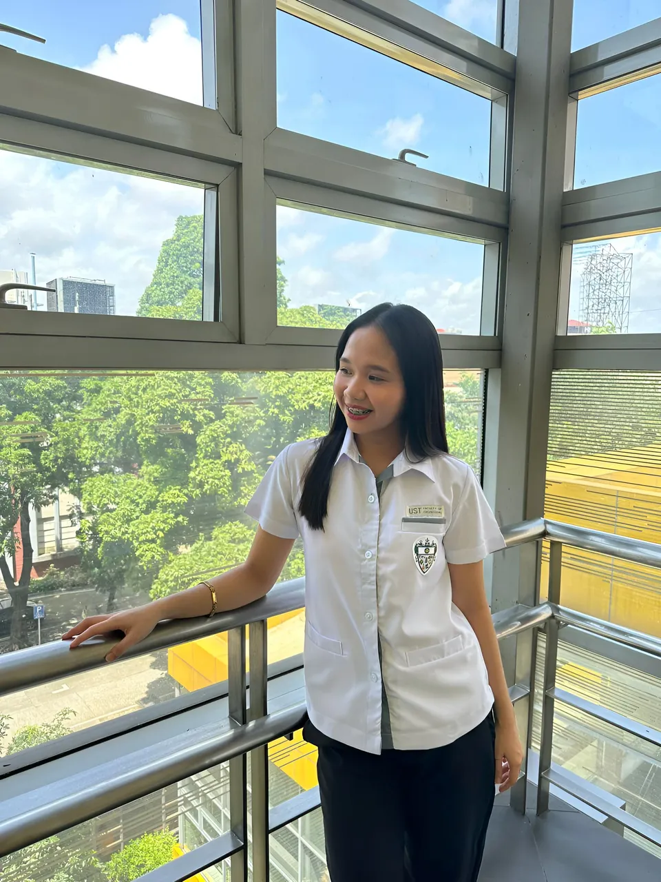 Faye Ramos in white shirt standing by balcony railing