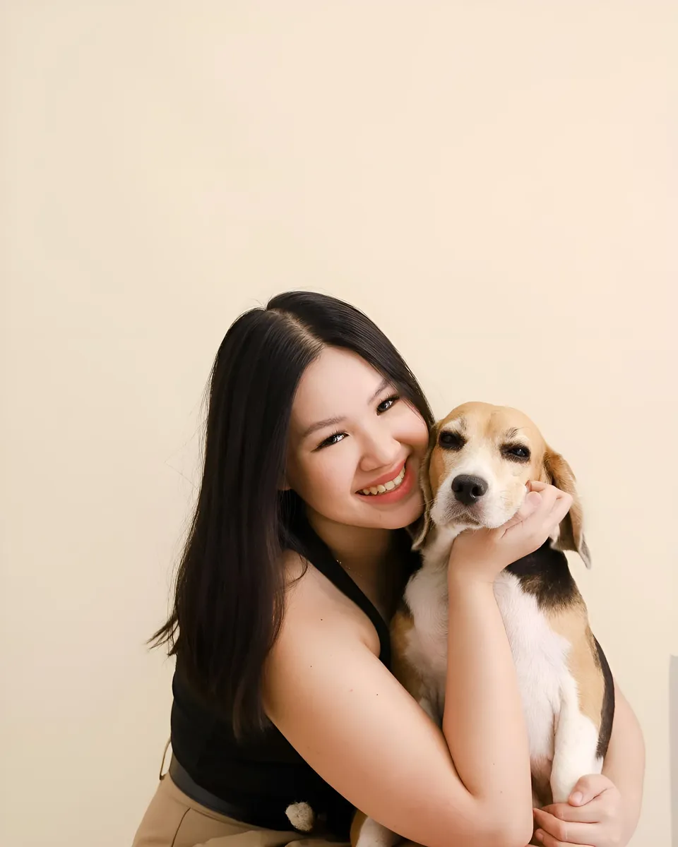 Genelleen Brooks holding beagle against plain background