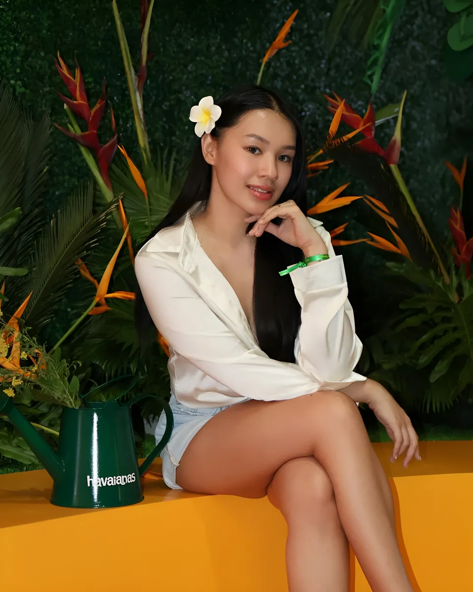 Genelleen Brooks in white shirt seated beside green watering can