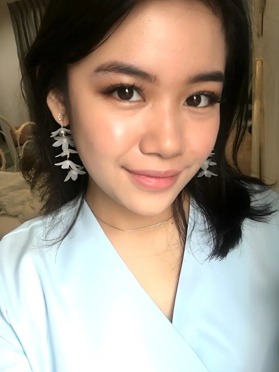 Humayra Gambar wearing light blue top with floral earrings