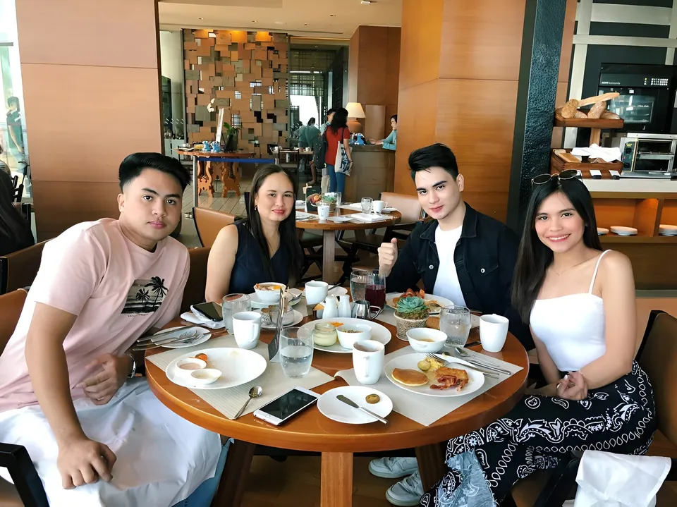 Ica Caparas — Four people seated at round table with breakfast items