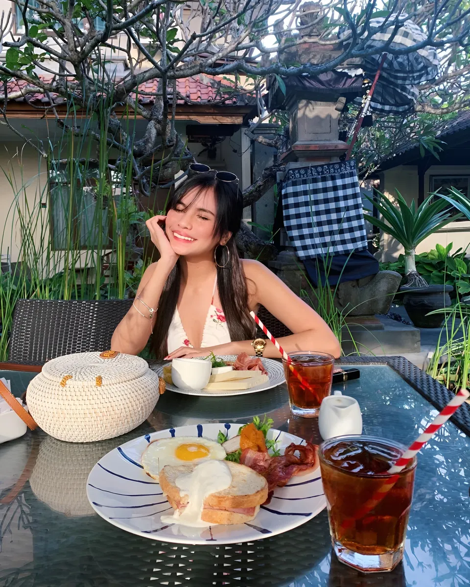 Ica Caparas seated at table with breakfast and drinks outdoors