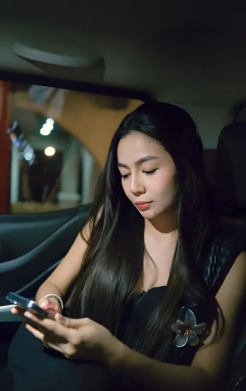Jainbre Morgan in black dress seated in car at night
