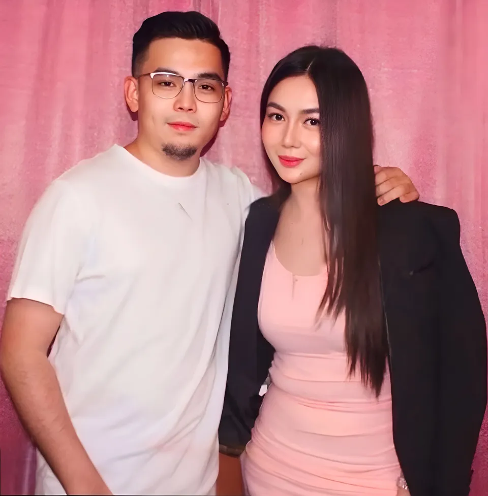 Jainbre Morgan and person posing together in front of pink curtain