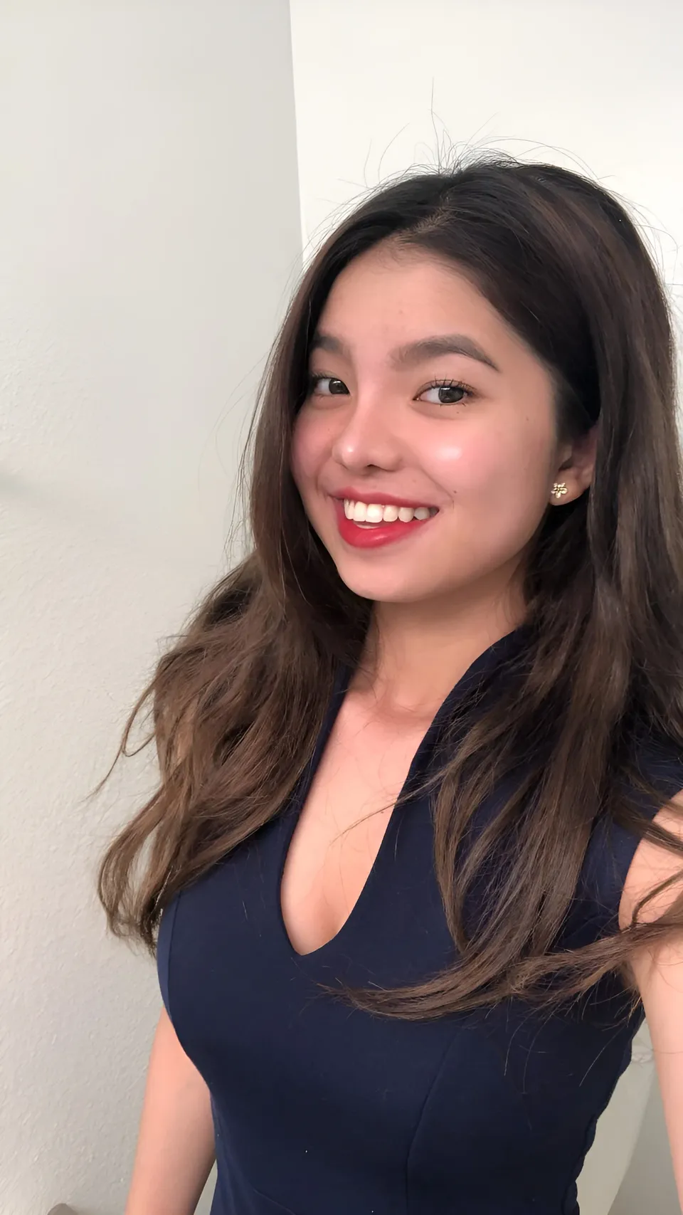 Jann Tiffany Mendoza smiling in dark blue top against plain wall