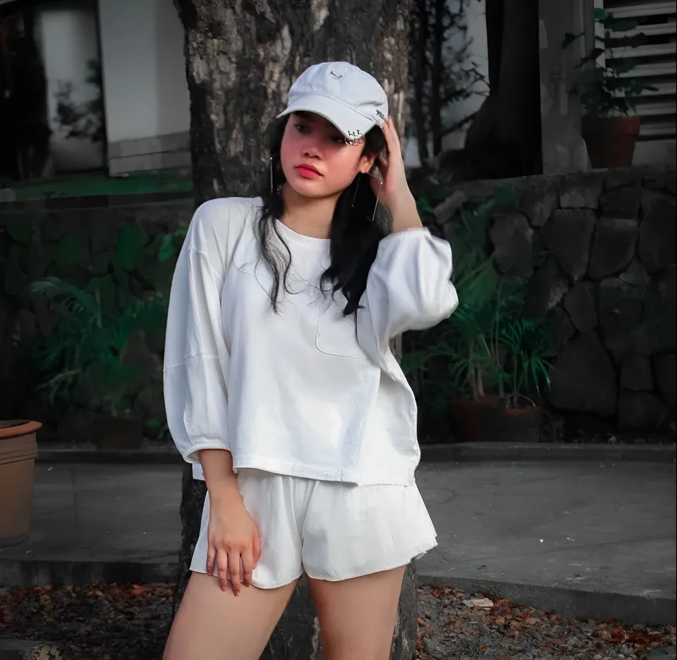 Jen Francisco in white outfit standing outdoors near tree