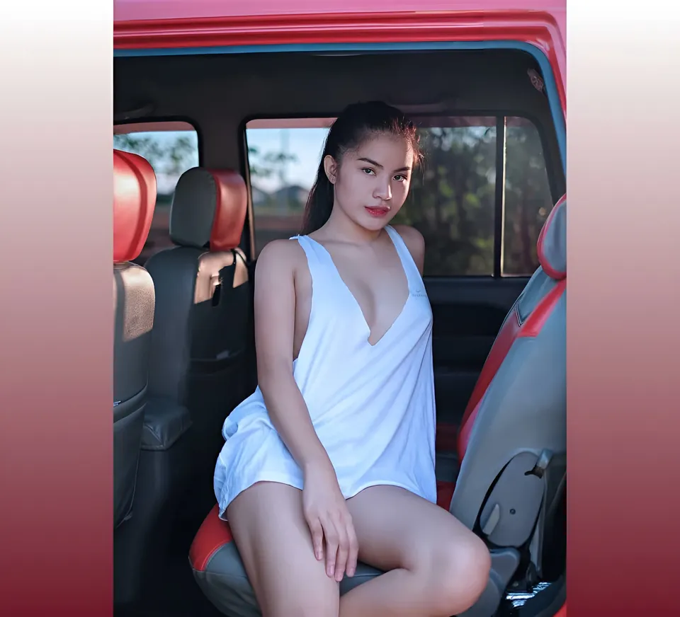Jennieva Quinn in white top seated inside red vehicle