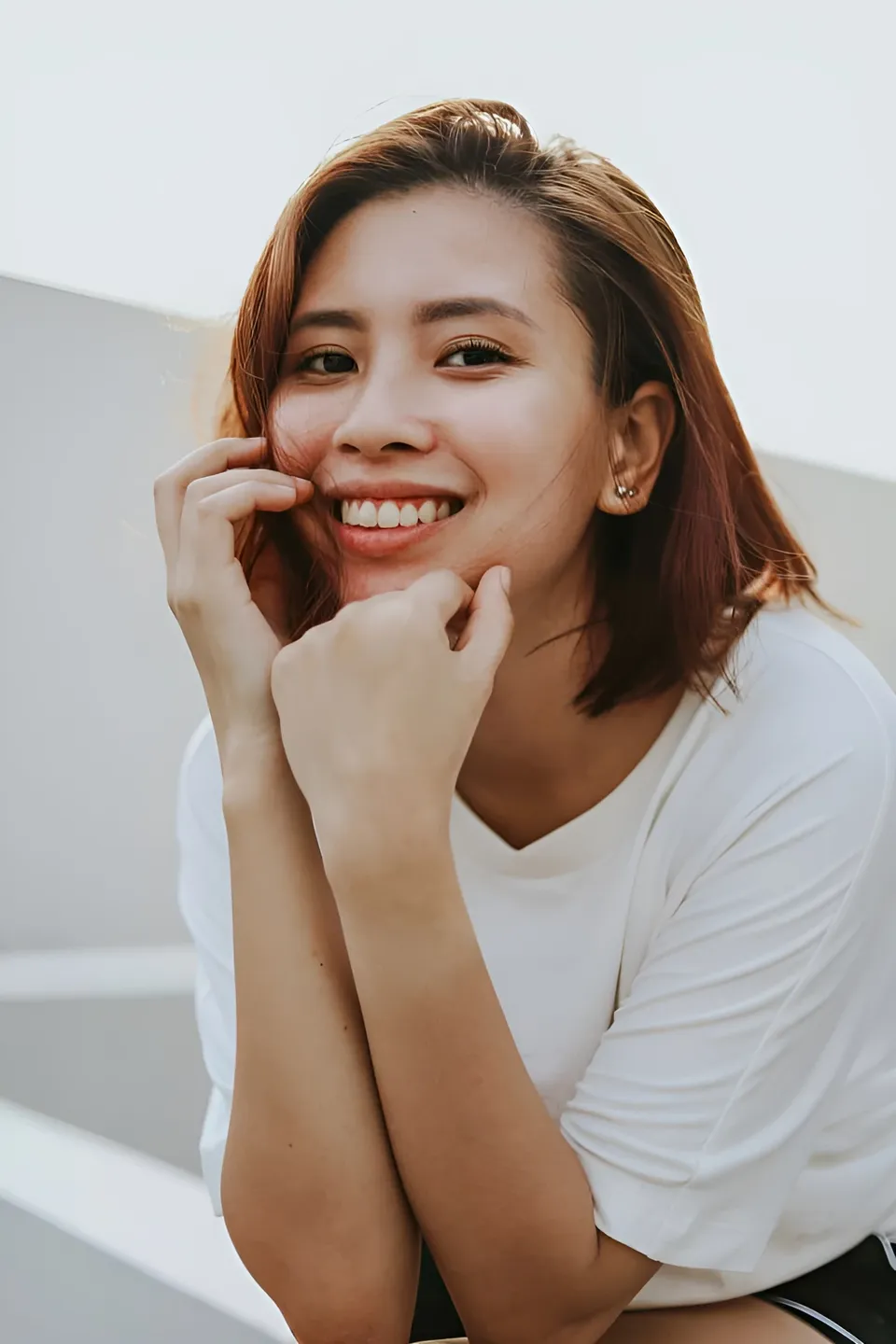Jessa Bariuan smiling with hands near face in white top