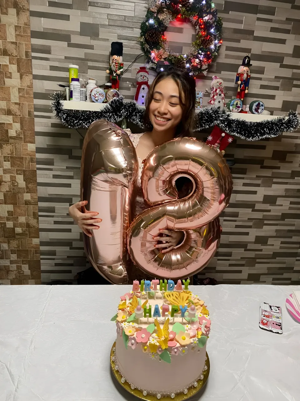 Joanna Colleen holding large number balloons with birthday cake in foreground