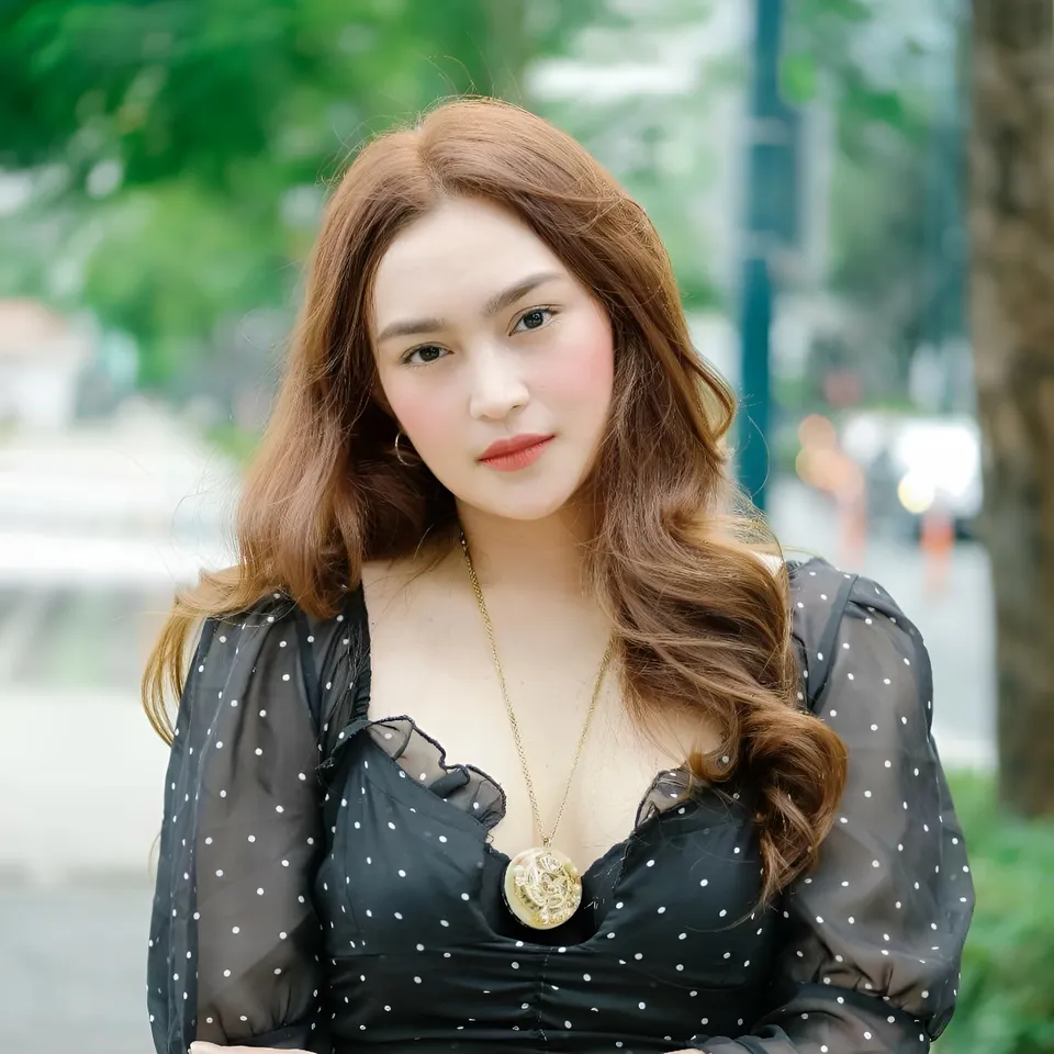 Julia Claire Anne Sotelo in black polka dot top with gold pendant necklace