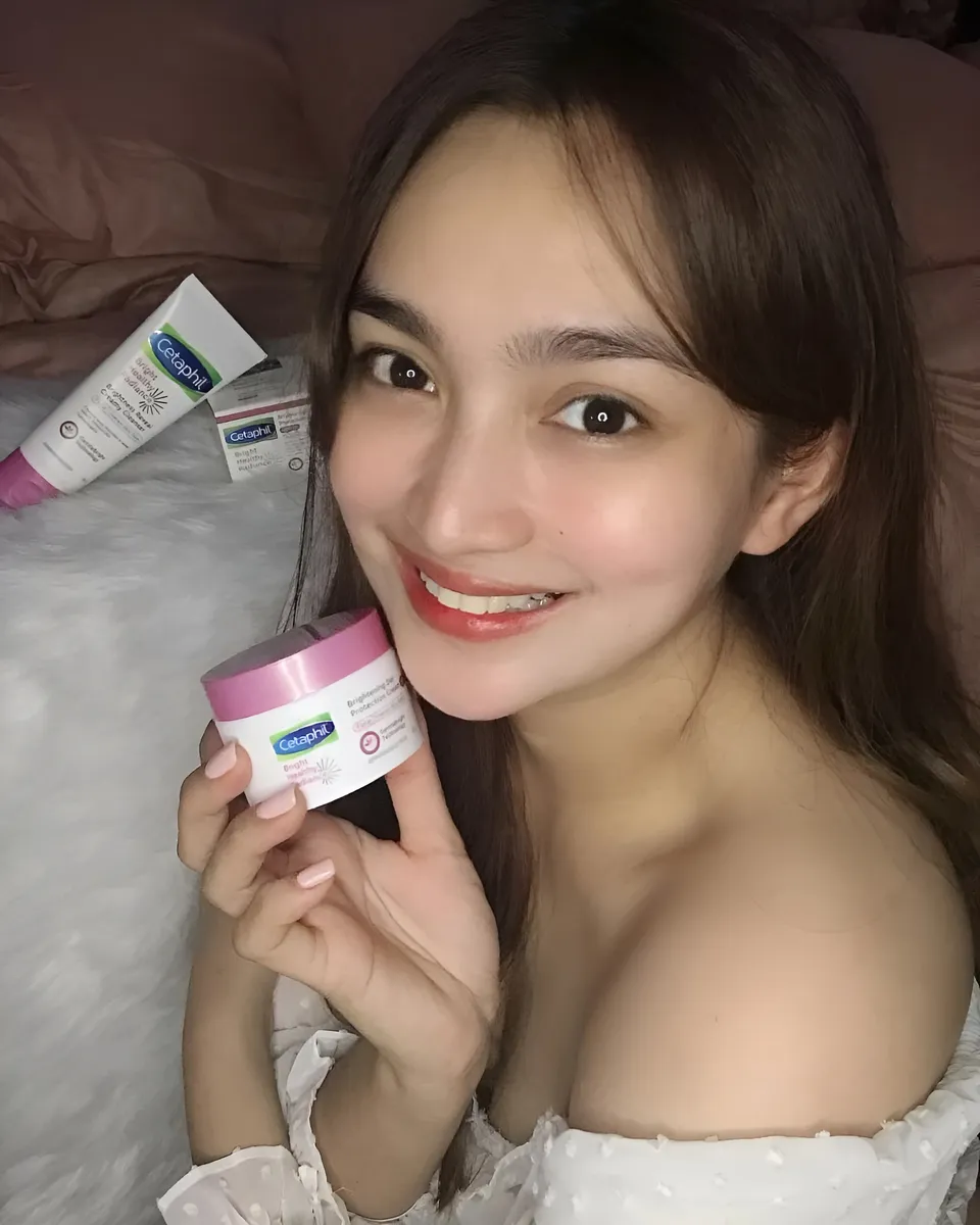 Julia Claire Anne Sotelo holding pink-capped skincare jar with other products nearby