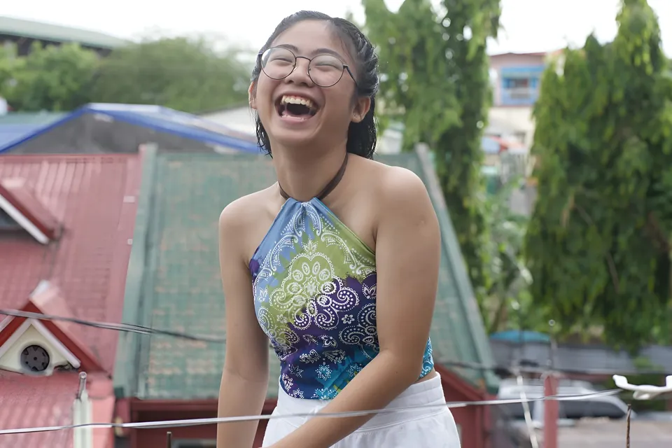 Julian Galan laughing with glasses in colorful top outdoors