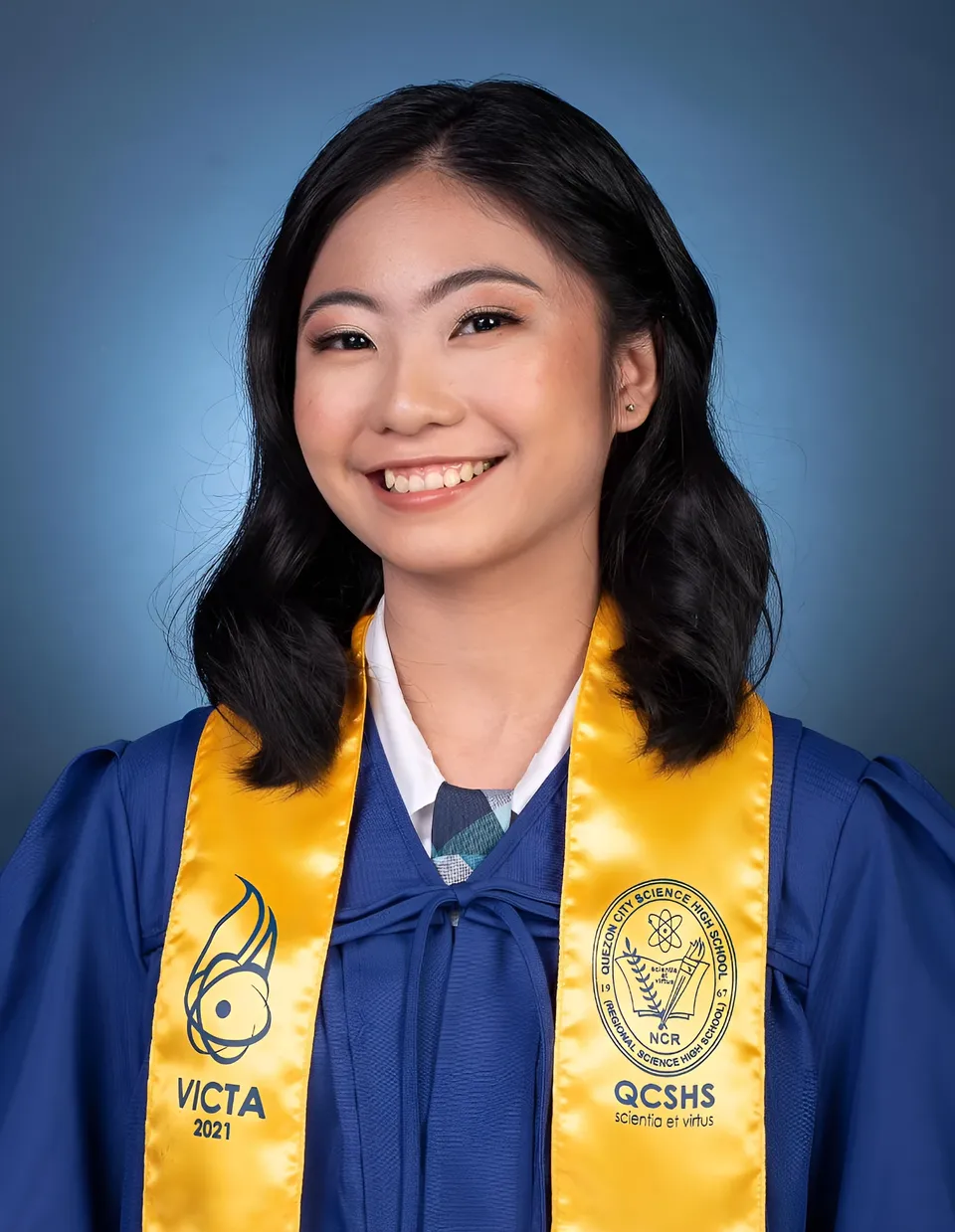 Julian Galan — Graduate in blue gown with yellow sashes and white collar