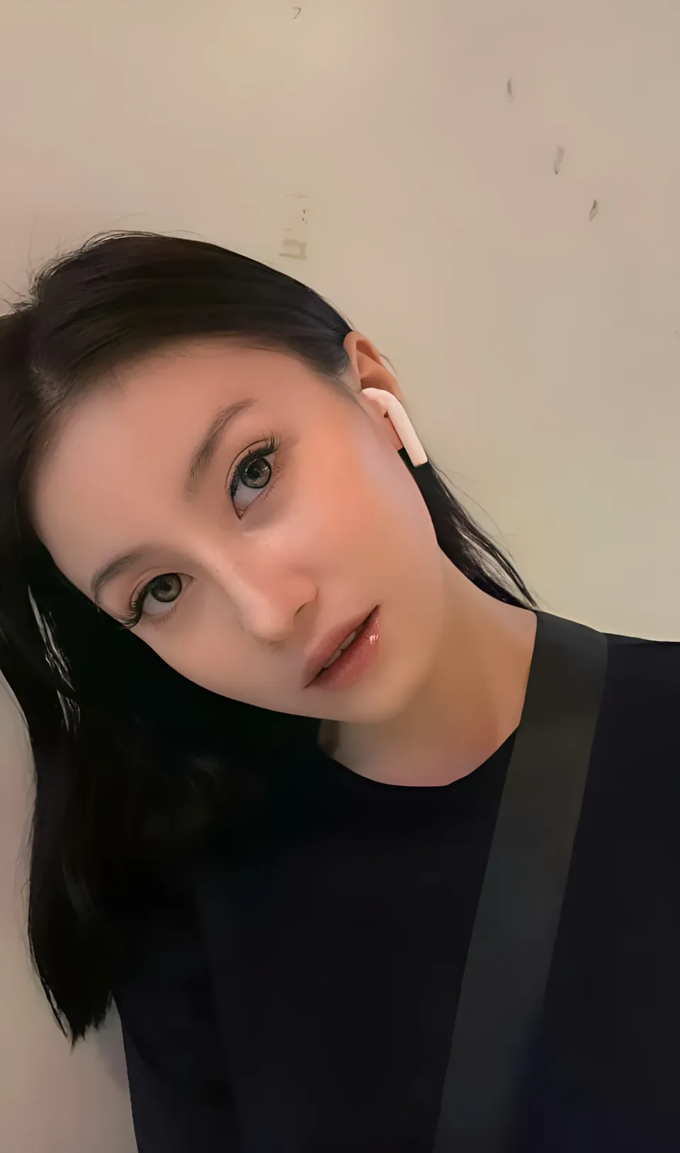 Justine Ponteras wearing black top with earbud in ear
