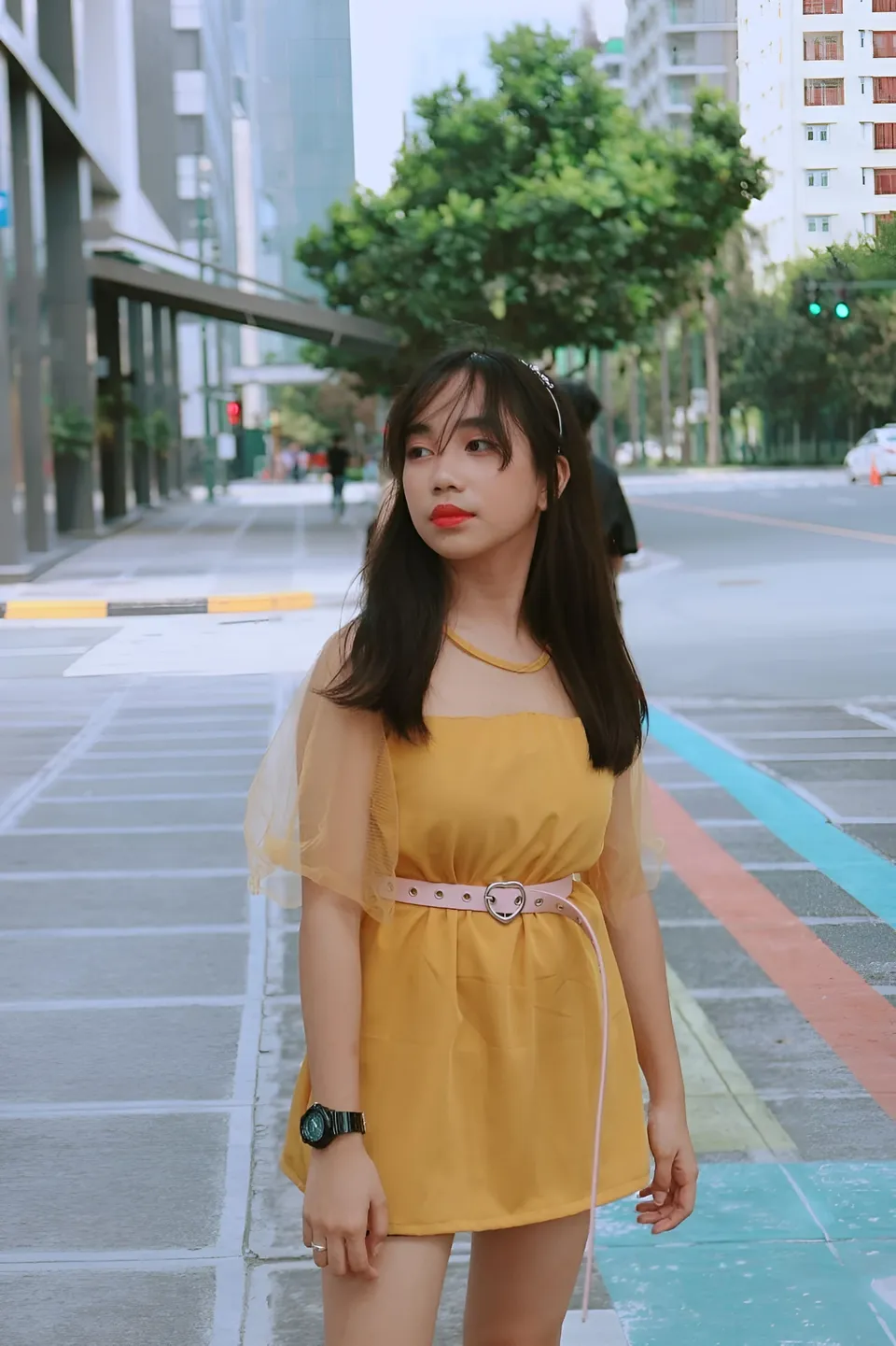 Kathleen Veronica in yellow dress standing on city street