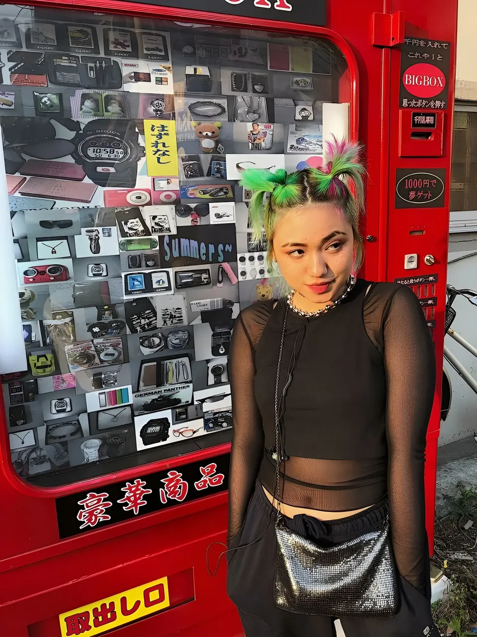Katy San stands beside red vending machine with merchandise display