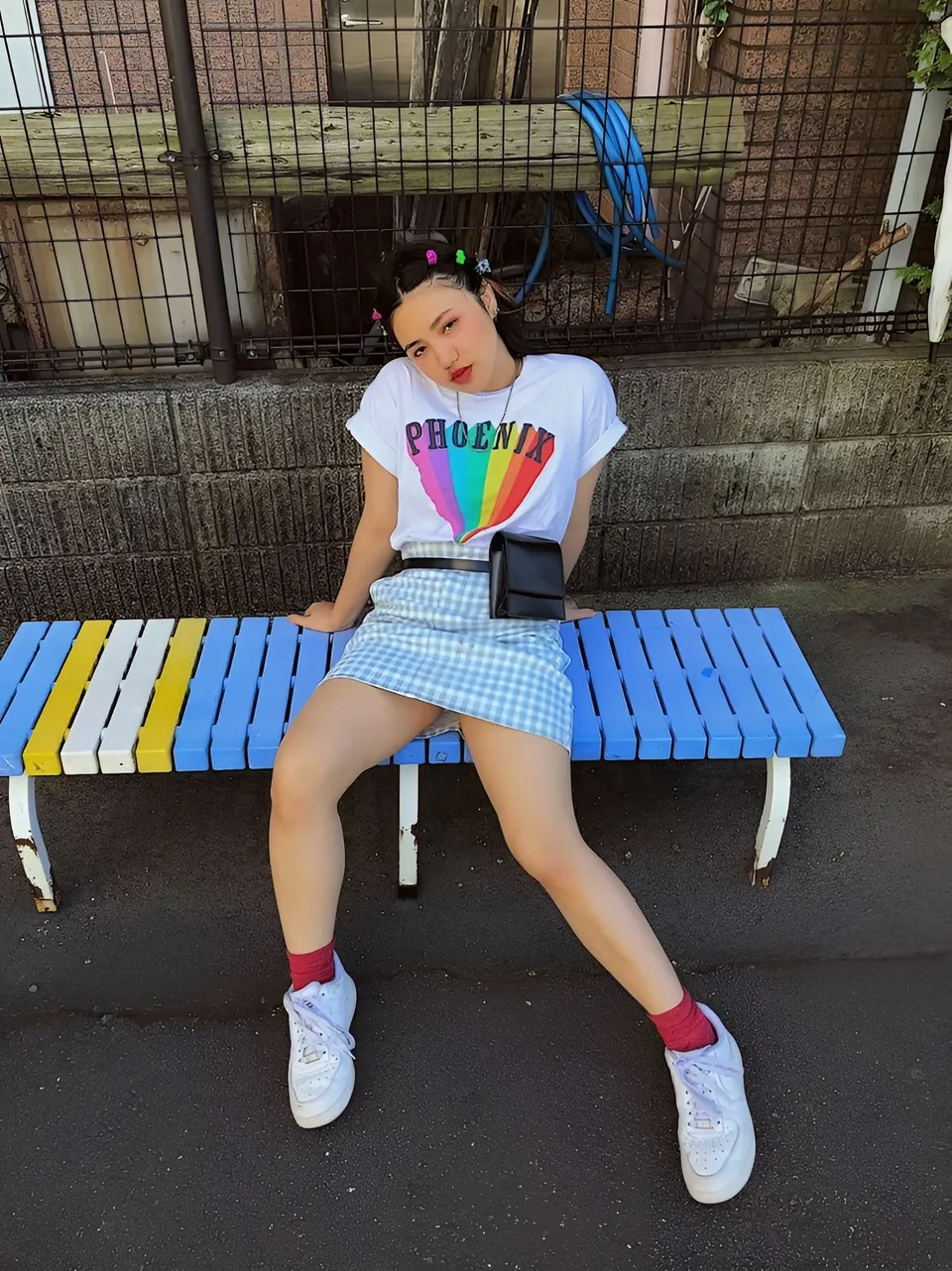 Katy San seated on colorful bench outdoors