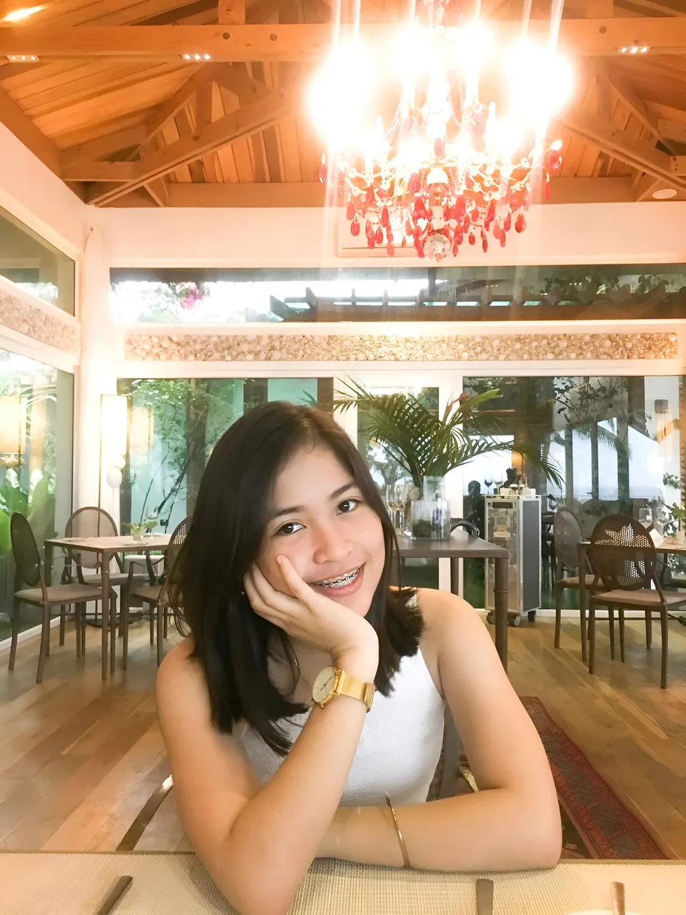 Kokies Lim in white top seated at table in warmly lit restaurant
