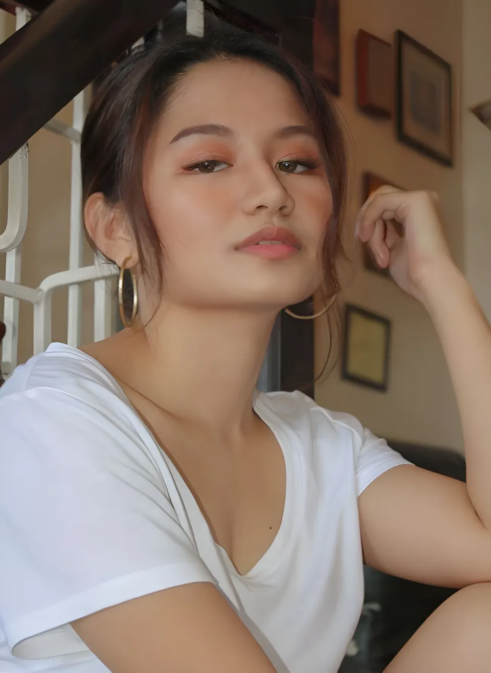 Krysta Matias in white top seated with hand near face